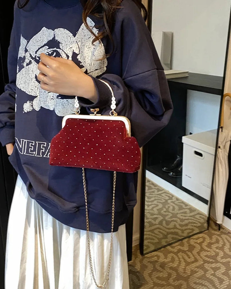 Velvet-look evening clutch Bianca Rose in burgundy with gold-tone handle and chain strap.