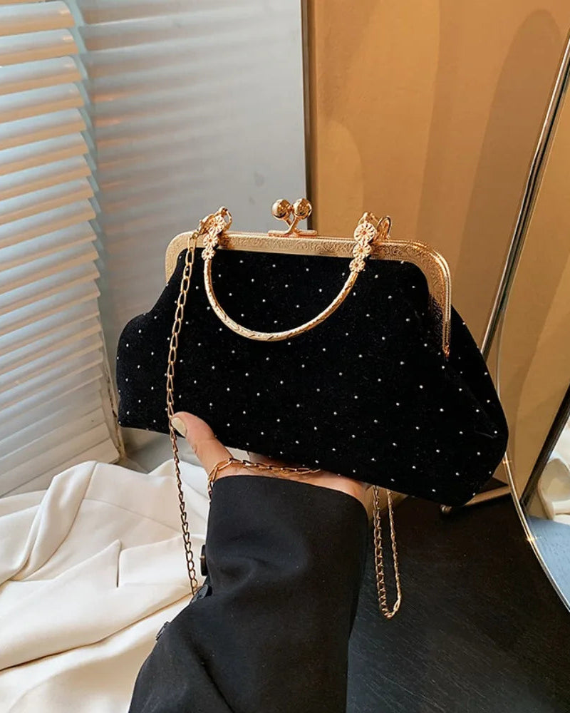 Velvet-look evening clutch Bianca Rose in black with gold-tone clasp frame and chain strap.